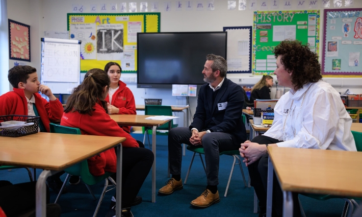 Thedailymile 82 Catherine Roche, Chief Executive of Place2Be, and Gordon Banks, Global Director of The Daily Mile, siting and talking with pupils from Churchfield Primary School