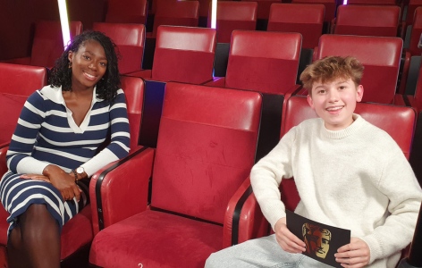 BAFTA Young Presenter Tristan Thompson with broadcaster Shanequa Paris, sitting on red theatre seats