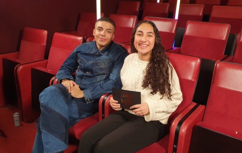 BAFTA Young Presenter Samaira Iqbal with actor Jay Lycurgo, sitting on red theatre seats