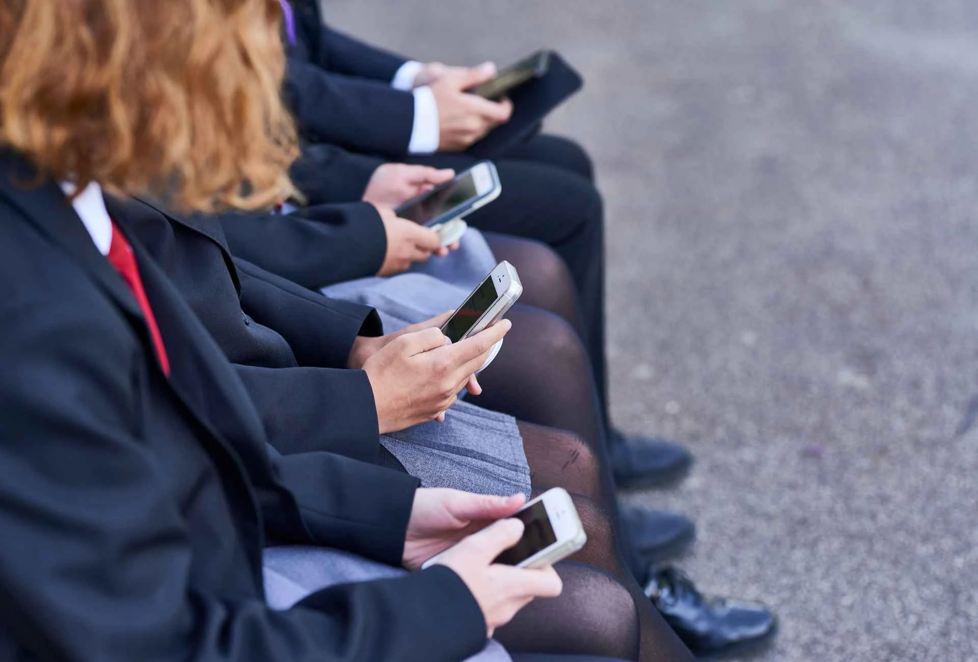 Young people looking at their mobile phones Young people looking at their mobile phones