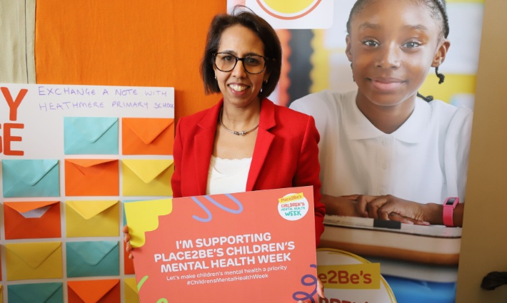 Munira Wilson holding a sign saying 'I'm supporting Place2Be's Children's Mental Health Week