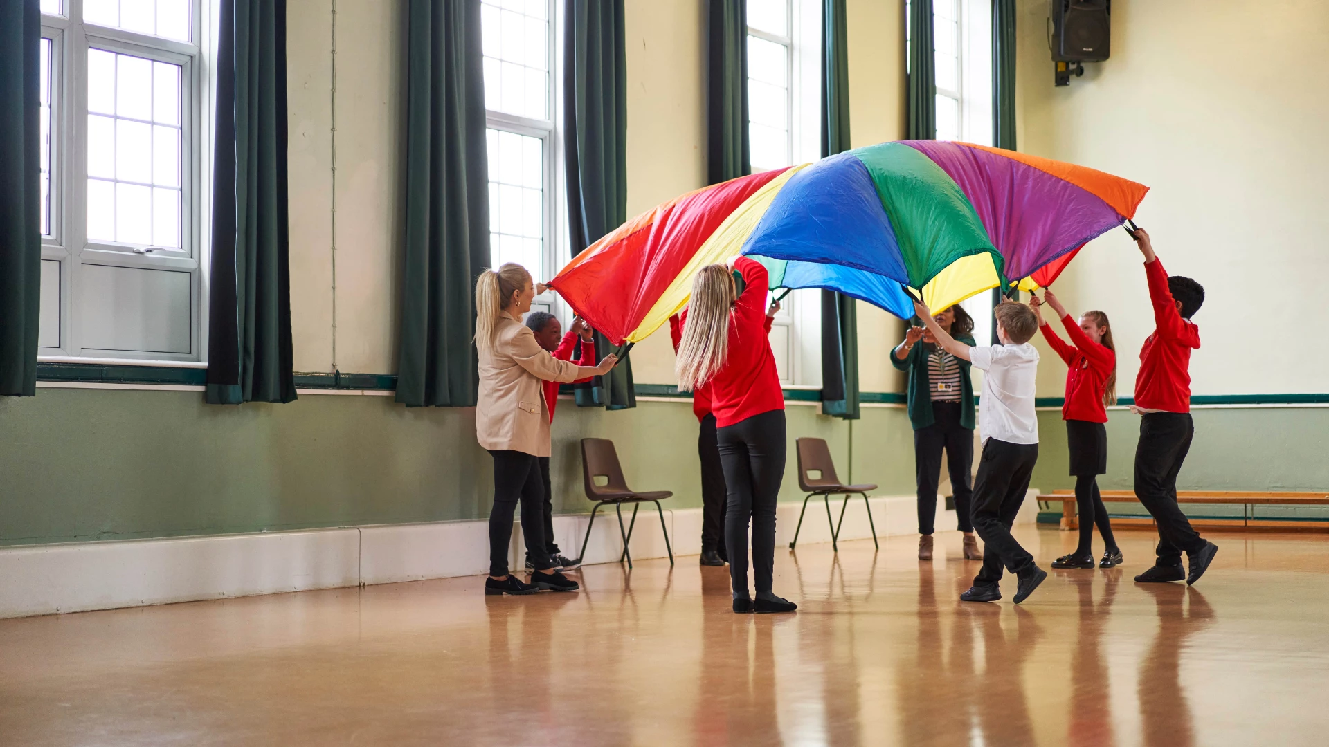People holding up a rainbow coloured parachute People holding up a rainbow coloured parachute