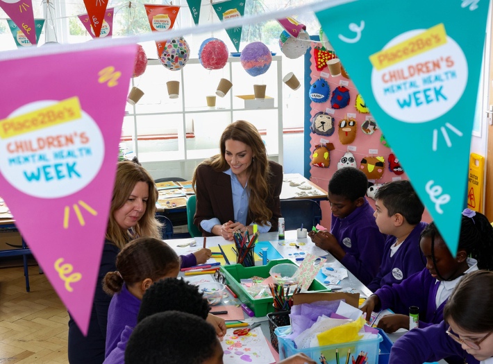 The Princess of Wales, Patron of Place2Be, sitting with pupils from Castle Hill Academy. They are busy crafting and using the official Children's Mental Health Week art activity.