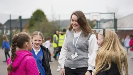 Place2Be counsellor chatting in playground to some children