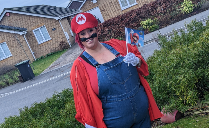 Woman dressed in a Super Mario costume, standing outside