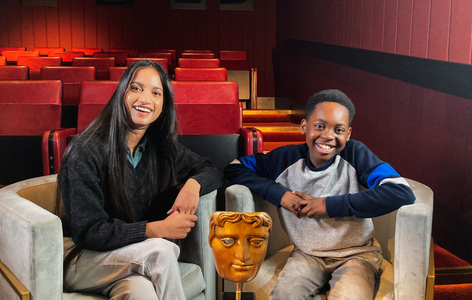 Actress Amita Suman sitting with BAFTA Young Presenter Jeriah